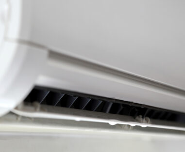 Close-up of an air conditioner vent grille with horizontal slats.